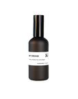 Day Dream Room Spray comes in a matte black bottle with a white band label and black text, offering an uplifting white tea and ginger scent. Its sleek design is ideal for refreshing any room.